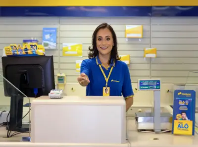 Mulher sorrindo, com uma camisa azule crachá dos Correios, estendendo a mão.